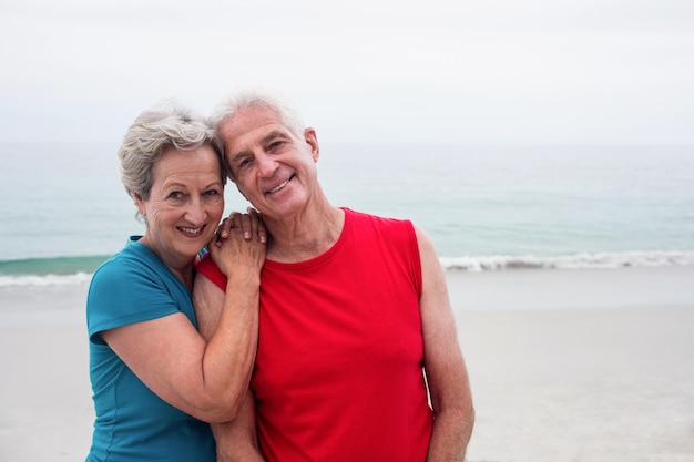 Heureux couple de personnes âgées s'embrassant sur la plage