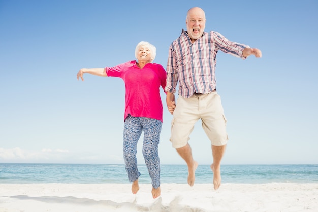 Heureux couple de personnes âgées sautant