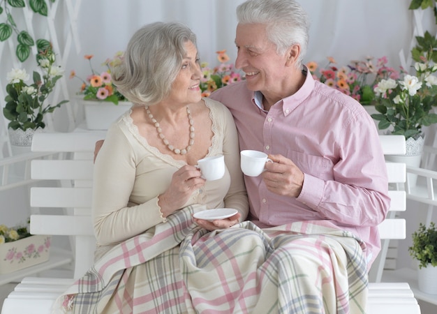 Heureux couple de personnes âgées se reposant à la maison avec des tasses à thé