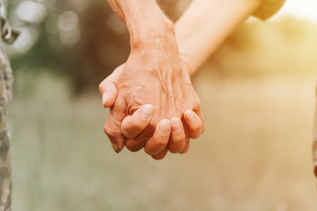 Heureux couple de personnes âgées tenant par la main les mains d'un homme et d'une femme se tiennent l'un l'autre romance et amour et soutien dans une famille âgée sans visage mari et femme voyagent ensemble dans la nature campagne vie flambée