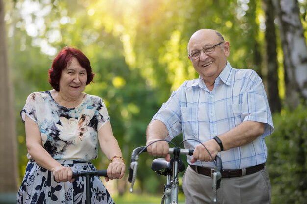 Heureux couple de personnes âgées avec un vélo