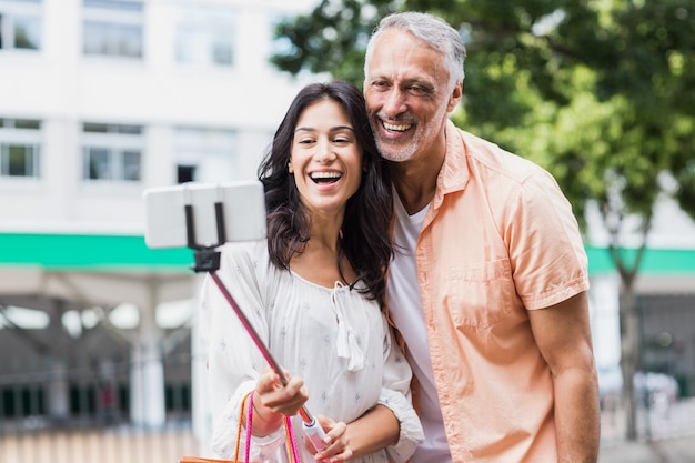 Heureux couple prenant selfie sur monopode