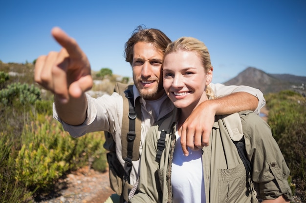 Heureux couple de randonnée marchant sur le terrain de montagne