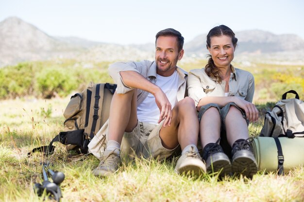 Heureux couple de randonnée prenant une pause sur le sentier de montagne