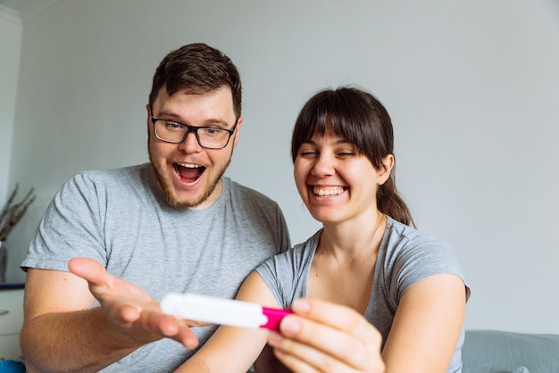 Heureux couple à la recherche d'un test de grossesse