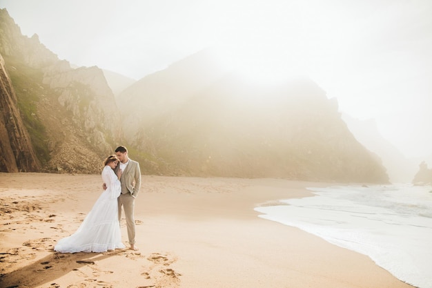 Heureux couple romantique d'âge moyen profitant d'une belle promenade au coucher du soleil sur la plage