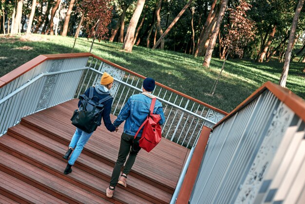 Heureux couple romantique de touristes se tiennent la main sur les marches vue arrière