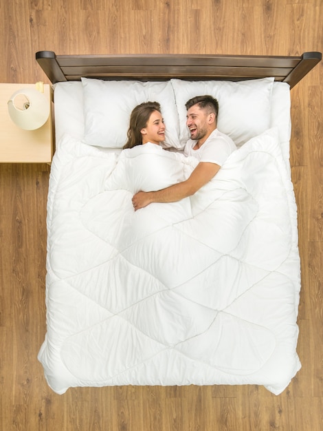 L'heureux couple s'allonge sur le lit. Vue d'en-haut