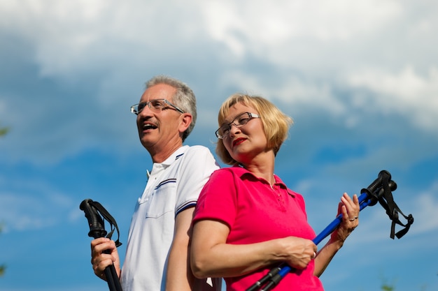 Heureux couple senior ou senior faisant de la marche nordique en été