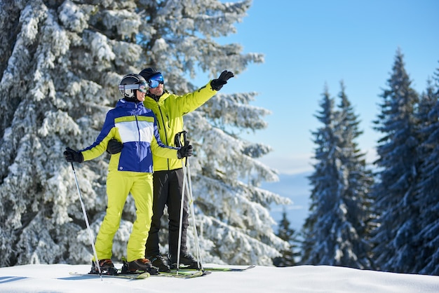 Heureux couple skieurs posant sur des skis avant de skier à la station de ski