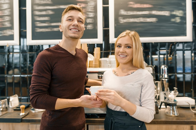 Heureux couple souriant au comptoir du café