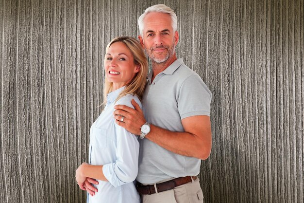 Photo heureux couple souriant à la caméra contre des planches de bois