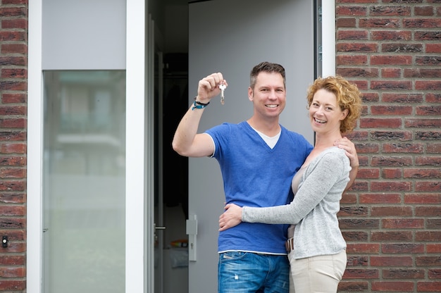 Heureux couple souriant à l&#39;extérieur de la nouvelle maison