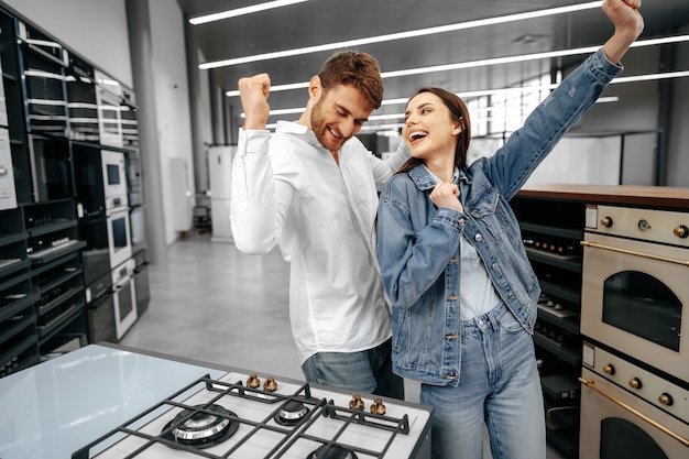 Heureux couple souriant vient d'acheter de nouveaux appareils ménagers en hypermarché