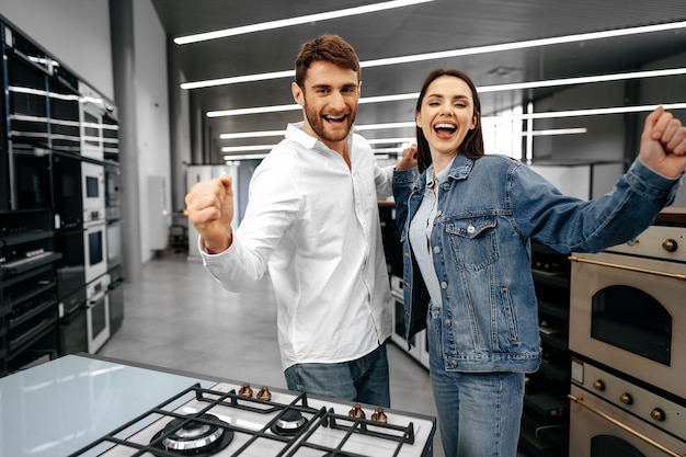 Heureux couple souriant vient d'acheter de nouveaux appareils ménagers en hypermarché