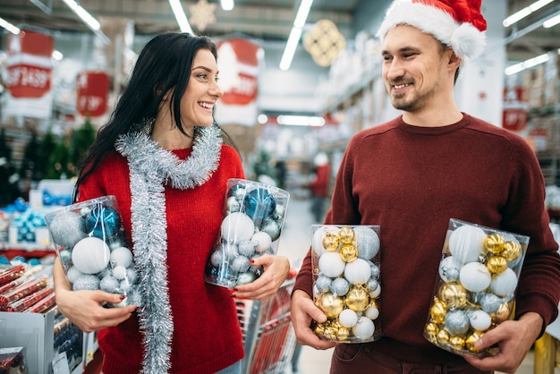 Heureux couple tient des boîtes avec des jouets de Noël