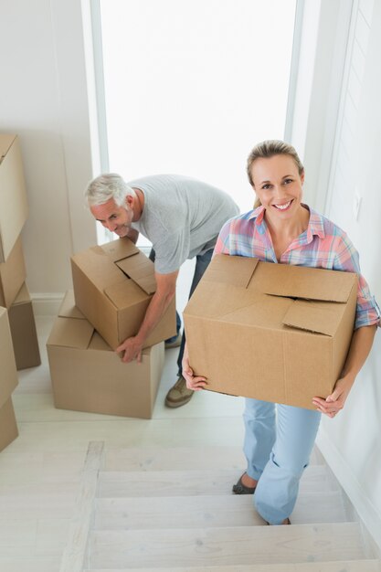 Heureux couple transportant des boîtes de déménagement en carton