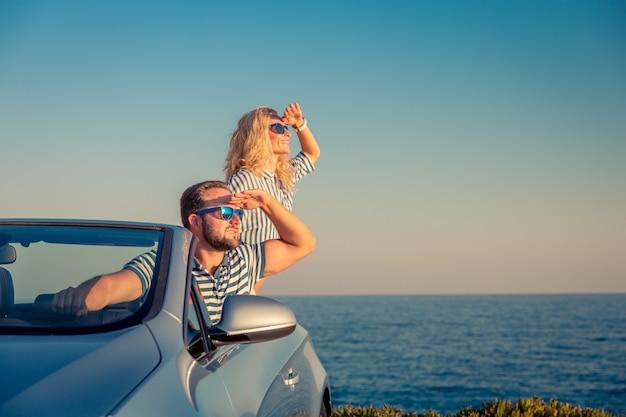 Heureux couple voyage en voiture Les gens s'amusant dans le concept de vacances d'été cabriolet bleu