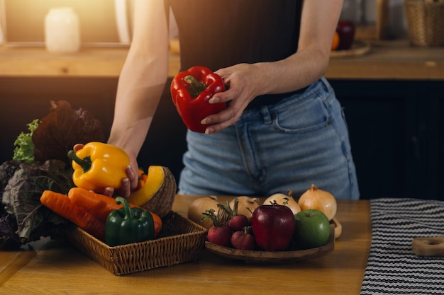 Heureux deux jeunes femmes à la recherche d'un ordinateur portable pendant la cuisson ensemble dans la salle de cuisine à la maison Deux jeunes femmes lesbiennes diverses passent du temps ensemble LGBT et concept d'identité de genre