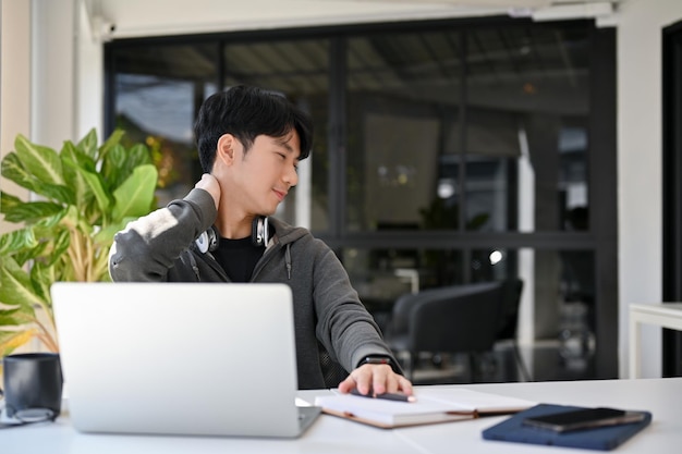 Heureux employé de bureau asiatique ou étudiant se détendre après avoir terminé son travail à son bureau