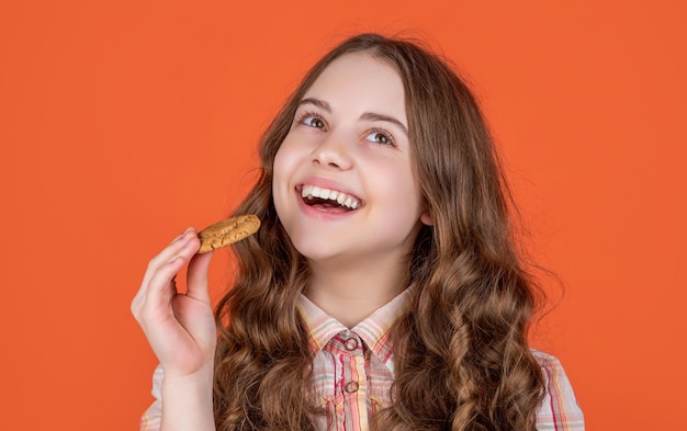 Heureux enfant adolescent avec des biscuits à l'avoine sur fond orange