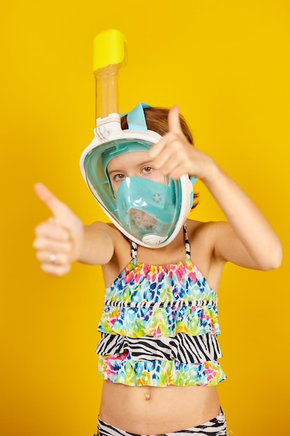 Heureux enfant adolescent fille avec en maillot de bain et masque de plongée en studio