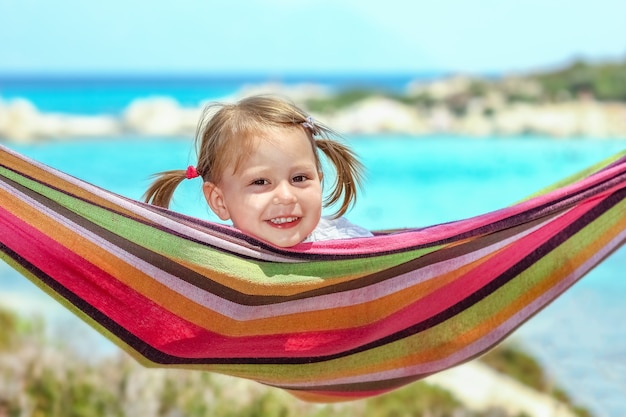 Heureux enfant au bord de la mer sur hamac