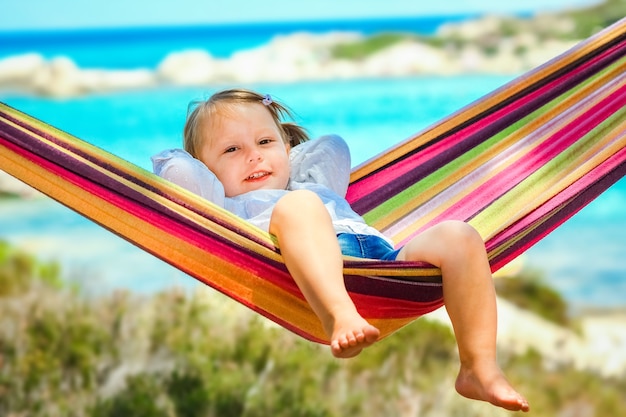 Heureux enfant au bord de la mer sur hamac