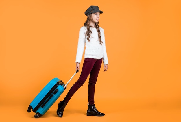 Heureux enfant en casquette avec valise de sac de voyage voyageant