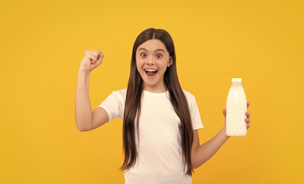 Heureux enfant étonné tenir boisson laitière adolescente va boire du lait