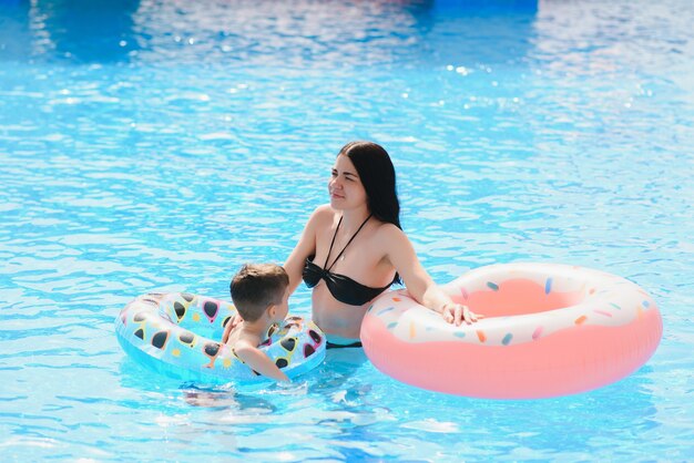 Heureux enfant et femme jouant dans la piscine avec structures gonflables