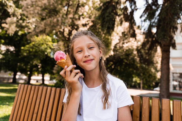 Heureux enfant fille avec cornet de crème glacée dans le parc d'été