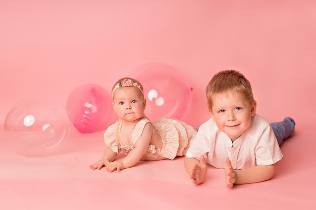 Heureux enfant fille et garçon avec des ballons roses.