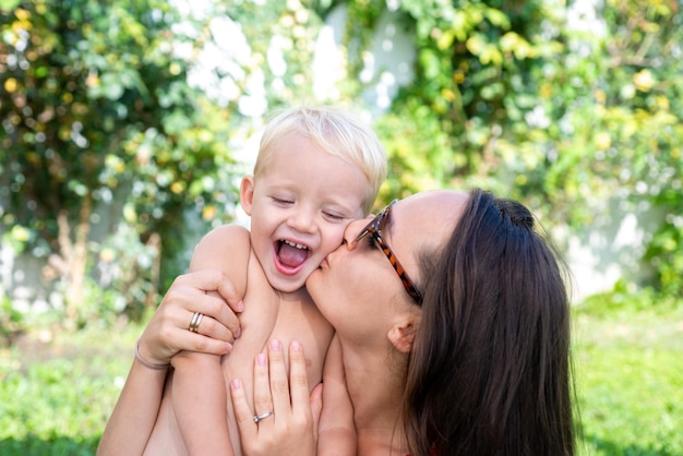 Heureux enfant fils câlin maman. Mère de famille et garçon souriant et s'embrassant.