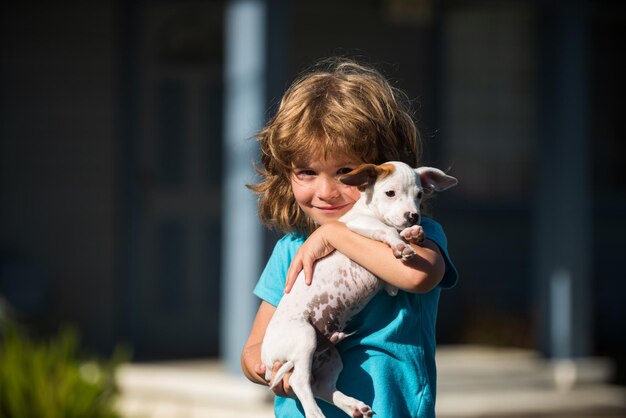 Heureux enfant garçon étreignant chien câlin amis