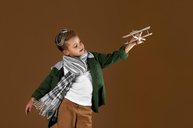 Heureux enfant garçon jouant avec un rêve d'avion jouet en bois