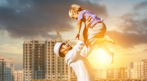 Heureux enfant garçon et son père sur fond de bâtiments élevés