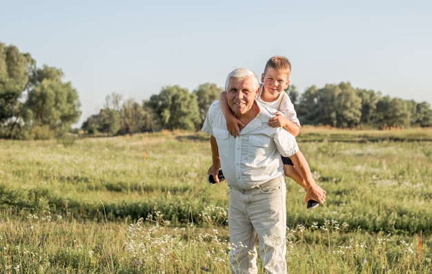 Heureux enfant avec grand-père jouant dans le pré