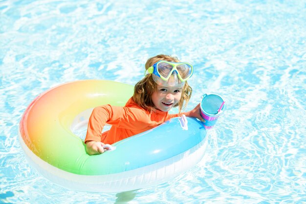 Heureux enfant jouant avec un anneau de bain coloré dans la piscine le jour de l'été enfant jouets d'eau enfants p