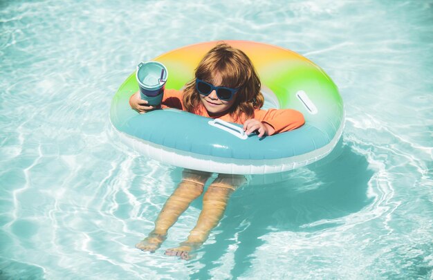 Heureux enfant jouant avec un anneau de flotteur de natation dans la piscine vacances d'été mode de vie sain de l'enfant