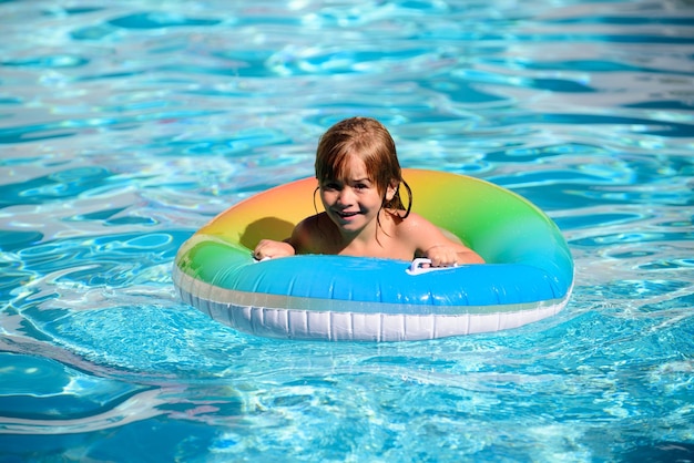 Heureux enfant jouant avec un anneau de flotteur de natation dans la piscine vacances d'été mode de vie sain pour les enfants