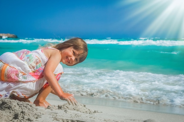 Heureux enfant jouant au bord de la mer à l'extérieur