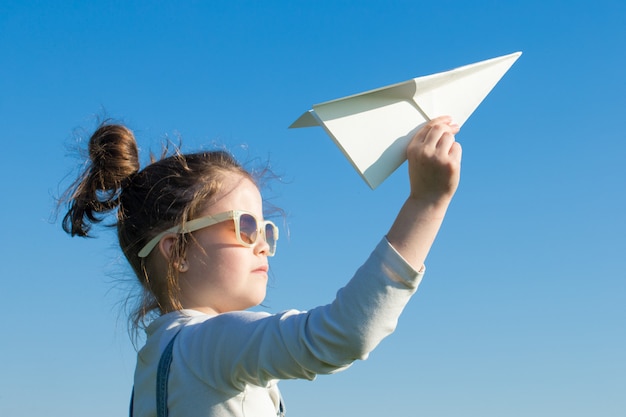 Heureux enfant jouant avec un avion en papier