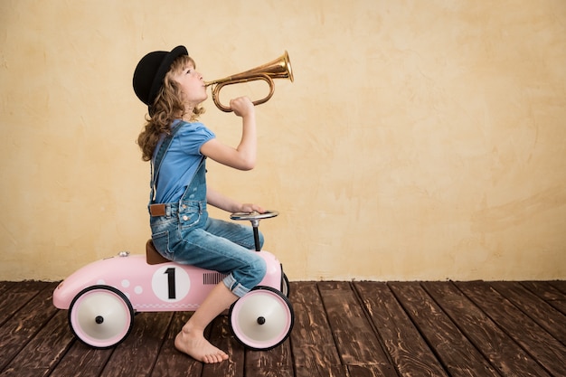 Heureux enfant jouant à la maison. Voyage en voiture. Concept de vacances et de voyage d'été