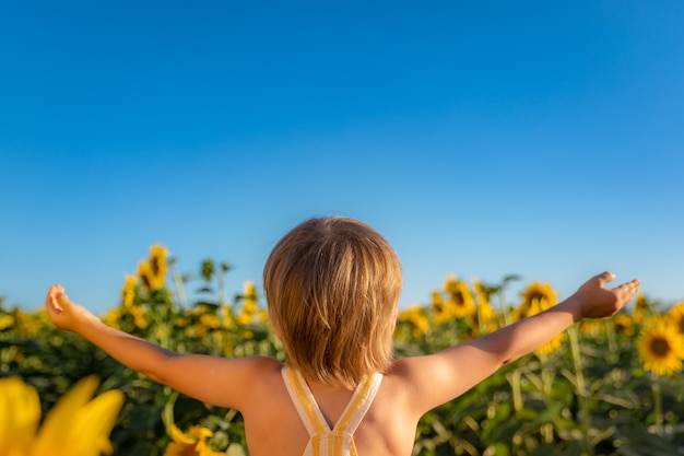 Heureux enfant jouant avec le tournesol en plein air