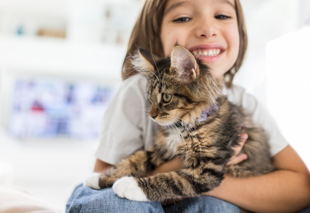 Heureux enfant à la maison jouant avec chat chat