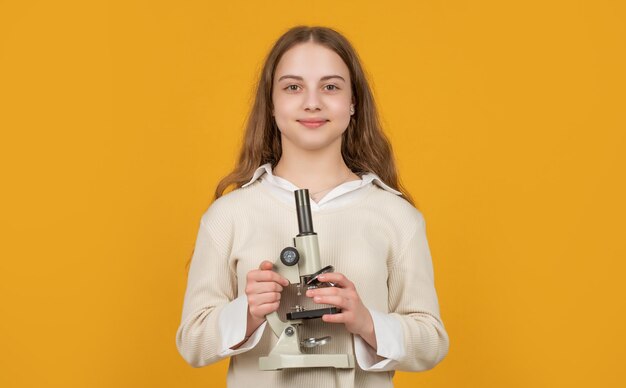 Heureux enfant avec microscope sur fond jaune