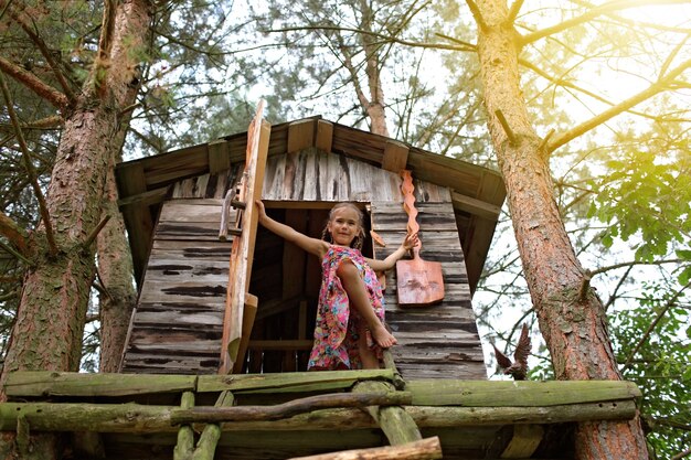 Heureux enfant mignon jouant dans la cabane dans les arbres