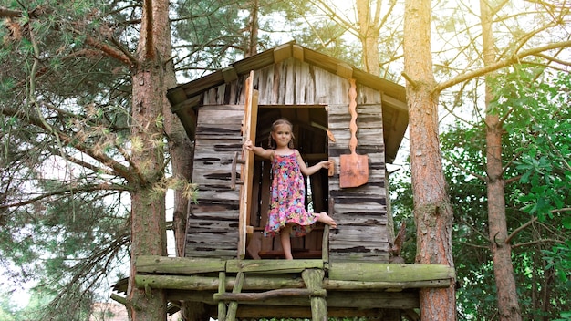 Heureux enfant mignon jouant dans la cabane dans les arbres