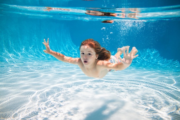 Heureux enfant nage dans la piscine enfant actif sous l'eau nageant sous l'eau jouant et s'amusant enfants w